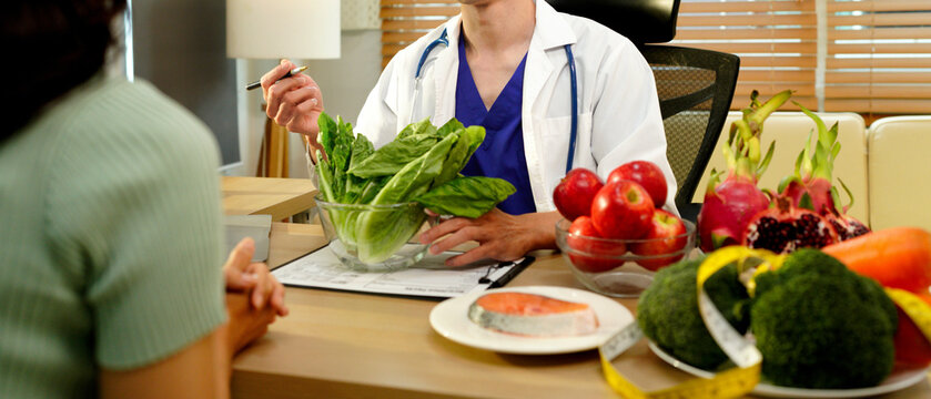 Dietician, male nutrition specialist consulting woman, developing healthy diet, dietary program. Dietary consultant asking, giving male patient advice, help, nutritional information, new meal plan