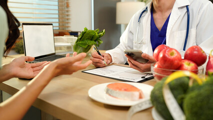 Dietician, male nutrition specialist consulting woman, developing healthy diet, dietary program. Dietary consultant asking, giving male patient advice, help, nutritional information, new meal plan