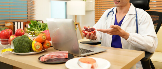 Nutritionist giving working on laptop and consultation to patient with healthy fruit and vegetable, Right nutrition and diet concept