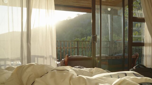 The morning sunlight shines on the balcony, the breeze moves the curtains, and there is a forest view outside the window