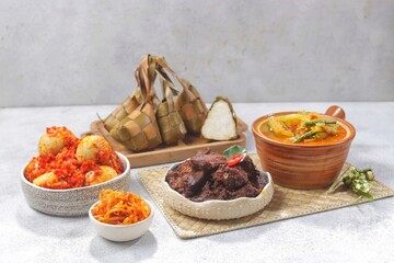 Ketupat Lebaran atau Eid Ketupat. The dishes served during Eid al-Fitr and Eid al-Adha are Ketupat, Opor Ayam, Rendang, Telur Balado, Sayur Labu Siam, and Sambal Goreng Hati. Selective Focus .