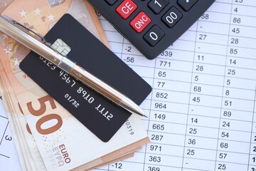 Credit card and pen with euro currency money bills banknotes on calculations document background. Business, financial operations and accounting in European Union