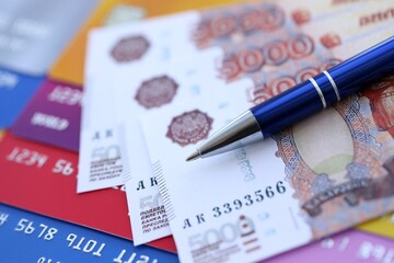 Credit cards and pen with Russian ruble currency money bills banknotes. Business, financial operations and accounting in Russian Federation