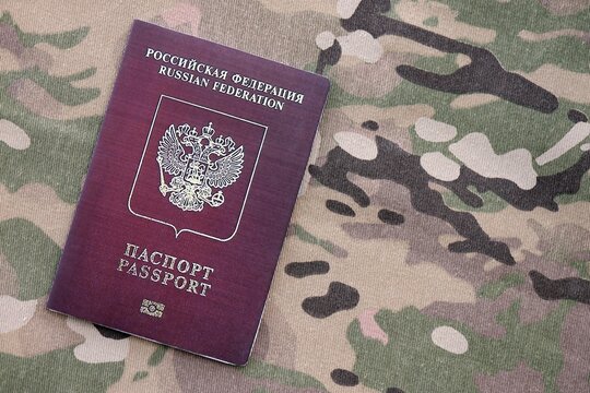 Russian passport on multicam camouflage fabric close up. Concept of russian army and invasion to Ukraine