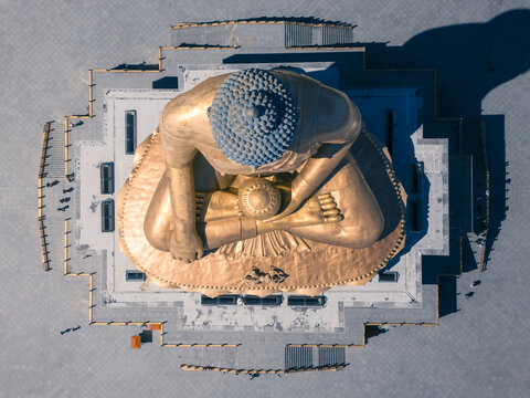 Aerial view of the gilded, gigantic Buddha Dordenma statue radiates against the muted grays of its platform, a spiritual sentinel overlooking the valley, Thimphu, Thimphu, Bhutan.