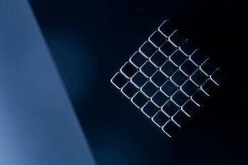 Abstract geometric pattern of metallic square magnetic cubes on dark blue background. Concept of...