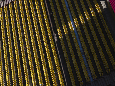 Aerial view of rows of yellow seats stand in stark contrast to the dark shadows, creating a mesmerizing pattern of light and shade, Thimphu, Bhutan.