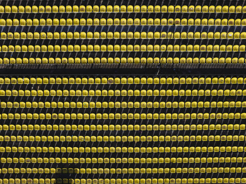 Aerial view of vibrant yellow seating rows contrast sharply against the dark framework, creating a mesmerizing pattern from above, Thimphu, Bhutan.