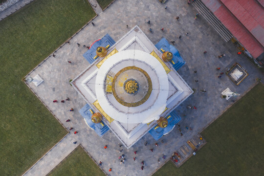 Aerial view of the National Memorial Chorten, with its gold spire piercing the sky above the white stupa, surrounded by devotees, Thimphu, Bhutan.