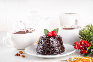 Traditional English Christmas pudding mug cake. Simple Christmas pudding recipe idea, made on tea mug with microwave, portioned Christmas pudding with sugar powder and cranberry festive decor