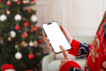 Christmas-themed phone mockup with hand tapping the screen, perfect for mobile app previews, winter...