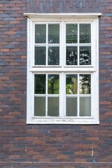 White mullioned window in brick wall