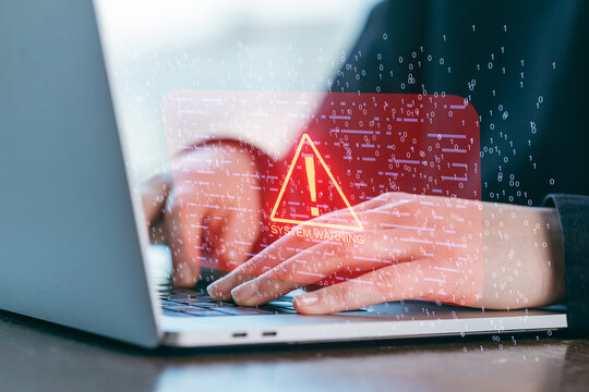 System alert appears on laptop while individual types on keyboard in modern workspace - Powered by Adobe