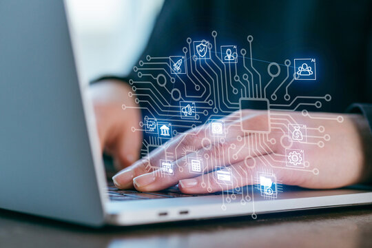 Hands typing on a laptop with digital icons and circuit patterns, illustrating technology and connectivity in modern work settings