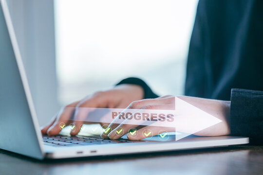 Hands typing on a laptop with a progress indicator displayed on the screen in a bright workspace environment