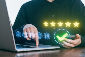 Person checking reviews and ratings on a laptop while using a smartphone during a work session