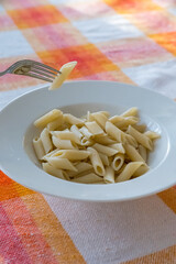 Fork Lifting Plain Cooked Penne Pasta Dish