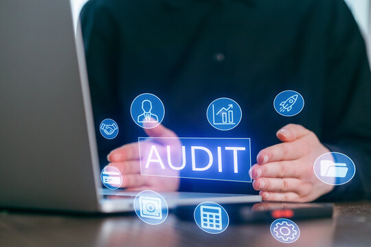 Professional conducting an audit while using a laptop in a modern workspace with digital icons representing various business functions