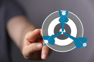 Hand pointing at darts on a target, representing goal achievement, business success, and strategic planning. Perfect for marketing and business