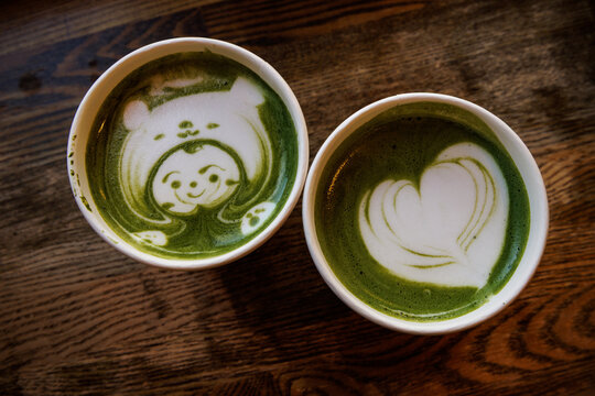 Two cups of matcha latte with cute latte art
