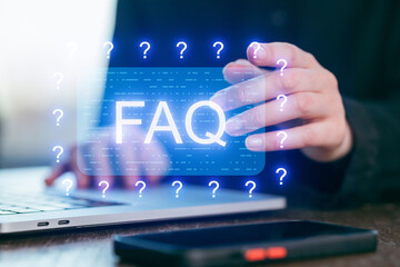 FAQ section being updated on a laptop with a digital interface showing question marks and information