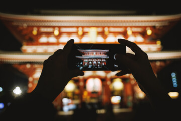 Night photo of Japanese temple on smartphone screen
