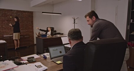 Multigenerational business associates collaborate on a project, analyzing data and strategizing in a modern office setting. - Powered by Adobe