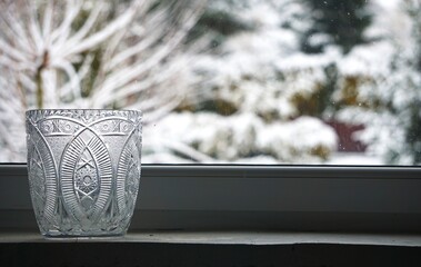 Duży, piękny, stary kryształowy wazon, modny w czasach PRL. Błyszczące szkło i klasyczny kształt podkreślają retro klimat i elegancję dawnej aranżacji wnętrza. © Adam