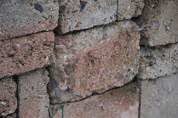 Stare, zaniedbane cementowe bloczki ułożone jeden na drugim. Surowa faktura i ślady czasu tworzą obraz przemijania oraz opuszczonego miejsca budowy.