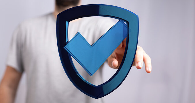 A man's hand interacting with a digital shield icon with a checkmark, symbolizing data protection, cyber security, validation, and co