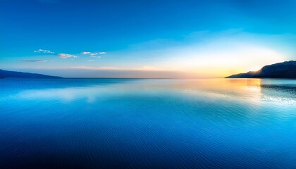 Fototapeta premium Deep Cobalt Blue Ocean Waters Reflected In A Still Lake Surface With Cerulean Hue At Sunset