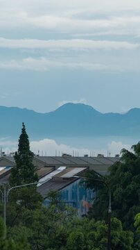 Vertical video - Timelapse of clouds calmly rolling under the mountain in the afternoon