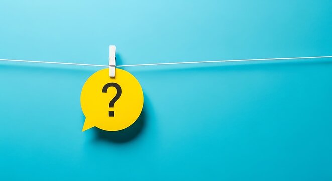Yellow speech bubble with a black question mark hanging from a string with a clothespin against a blue wall