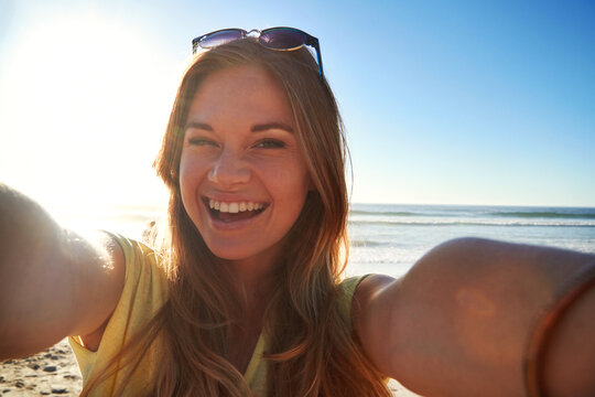 Face, girl and happy with selfie on beach for travel adventure, holiday memory and profile picture. Social media influencer, woman and photo at seaside for status update, online post and mockup space