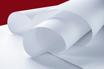 Rolled sheet of paper on a red background.