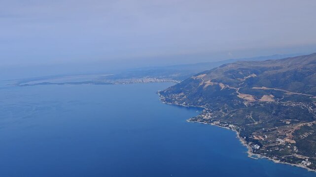 360&deg; aerial panorama of Vlore and Orikum, Albania, revealing sweeping coastal views, turquoise waters, mountain backdrop, and urban shoreline in bright, clear Mediterranean light.