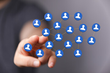 Abstract image showing interconnected digital network with hand interacting with people icons. Concepts of social media, technology, and global