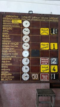 ELLA, SRI LANKA - NOVEMBER 2, 2025: A traditional wooden analog train schedule board at the Ella railway station, displaying departures and destinations in Sinhala and English.