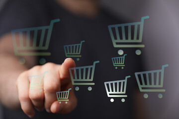 Hand pointing at shopping cart symbols representing online shopping and ecommerce, perfect for...
