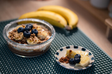 Overnight oats in glasses topped with banana slices and blueberries.