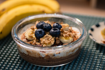 Overnight oats in glasses topped with banana slices and blueberries.