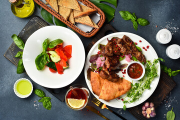 Food background. Fresh kebab, fresh vegetables and Georgian bread in a plate. Top view.