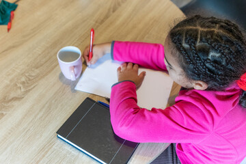 Young girl learning and developing cognitive skills while practicing writing and drawing, focusing...