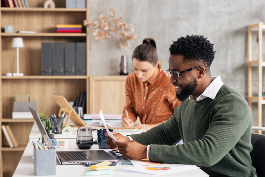 Diverse colleagues working together at shared office desk