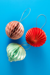 Bright paper decorations for the Christmas tree on a blue background. Christmas decorations.