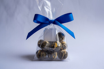 Dry Tea Balls in Clear Plastic Packaging Decorated with Blue Ribbon on White Backdrop