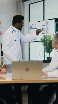 Medicine concept where good-looking purposeful high-skilled multicultural men and women-medical coworkers sitting around workplace and listening report from african american workmate