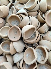 Close u shot of pile of  clay oil lamp.