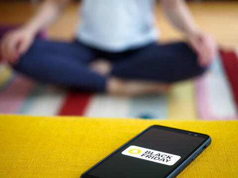 Woman Practicing Mindfulness Meditation Instead Of Black Friday Online Shopping On Smartphone