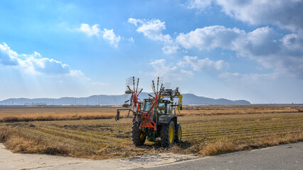 A view of Ganghwado's rice fields and a circular baler. Autumn rice fields after harvest. A view of Gyodongdo Island in Ganghwado. Korean traditional rice farming.
